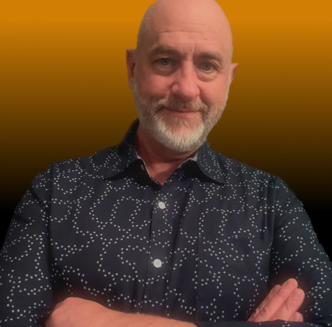 Doug Hudiburg, the founder, with his arms crossed and a slight smile, against an amber background that fades to black.